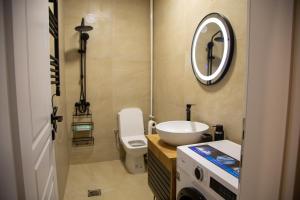 a bathroom with a sink and a toilet and a mirror at Stone Bridge 24 Apartment in Skopje