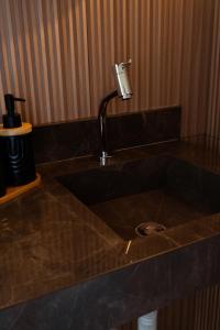 a kitchen sink with a faucet on a counter at Chalé Recanto da Paciência in Camanducaia