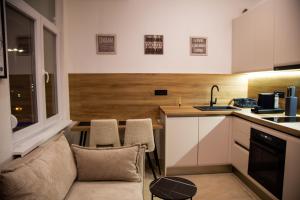 a living room with a couch and a kitchen at Stone Bridge 24 Apartment in Skopje +14 photos