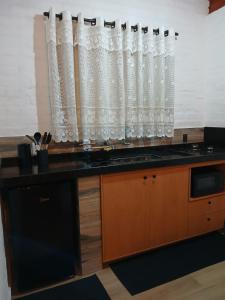 a kitchen with a sink and a window at Chalé Recanto da Paciência in Camanducaia +7 photos