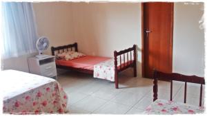 a bedroom with two twin beds and a fan at Apt. de Setiba - HOSPEDARIA OCA RUCA in Guarapari +11 photos