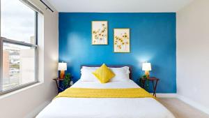 a bedroom with a blue wall and a bed at Modern Comforts Free Gym Access in Stamford