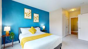a bedroom with a large bed with a blue wall at Modern Comforts Free Gym Access in Stamford +30 photos