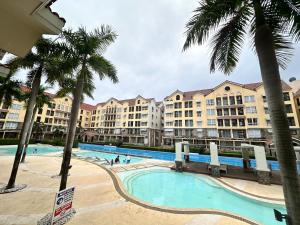 a large swimming pool with palm trees and buildings at CJ Premier Stays at Amalfi Oasis Near SM Seaside Mall & Nustar Casino Hotel, Cebu City in Cebu City