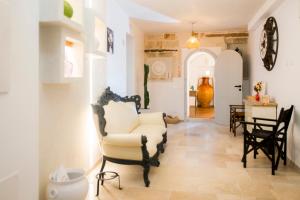 a living room with a chair and a table at Profumo Antico - Luxury Guesthouse by STHEY in Monopoli