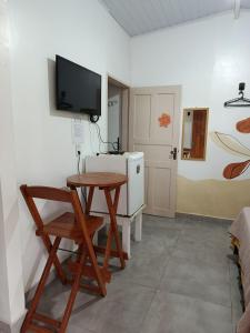 a room with a table and a television on a wall at Pousada Pedra das Amazonas in Parintins
