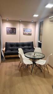 a living room with a black couch and a table and chairs at Casa container Hermosa zona in Paraná