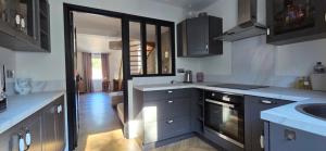 a kitchen with a sink and a stove at Le cocon d Épinal in Épinal