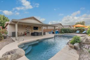 a swimming pool in front of a house at West Valley Pool Side Oasis in Surprise