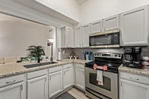 a kitchen with white cabinets and a stove top oven at West Valley Pool Side Oasis in Surprise