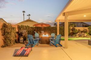 a patio with a table and chairs and an umbrella at West Valley Pool Side Oasis in Surprise