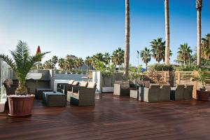 a patio with chairs and palm trees on a deck at Sea Lion Hotel in Montesilvano