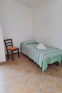 a small bedroom with a bed and a chair at Apartment Manna Hof by Interhome in Irgoli
