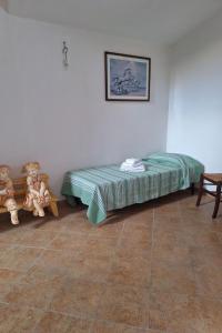 a bedroom with a bed and teddy bears in it at Apartment Manna Hof by Interhome in Irgoli