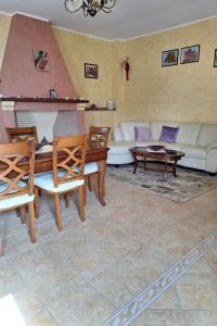 a living room with a couch and a table and chairs at Apartment Manna Hof by Interhome in Irgoli +15 photos