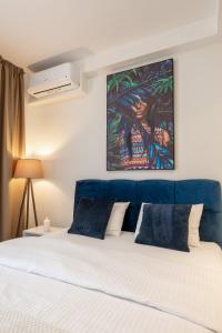 a bedroom with a bed with a painting above it at inJoy in Sajmište