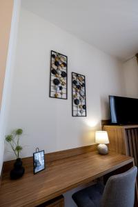 a room with a wooden desk with a tv and a table at inJoy in Sajmište