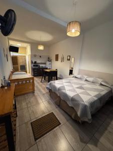 a bedroom with a large bed and a kitchen at Lofturbano Turístico in Mendoza
