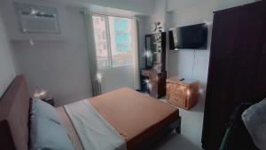 a bedroom with a bed and a tv and a window at Casa Aurora in Mandaue City +38 photos