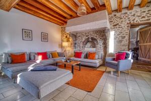 a living room with couches and a stone fireplace at Domaine Le Pineau Private Pool & Nordic Jacuzzi Loire Valley in Bléré +37 photos