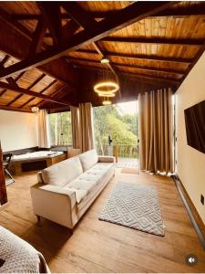 a living room with a white couch and a pool table at Cabana Dream Garden in Nova Friburgo