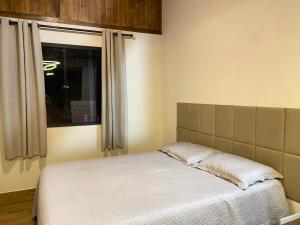 a bed in a room with a window at Cabana Dream Garden in Nova Friburgo