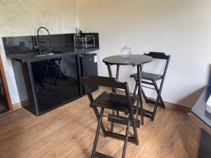a kitchen with a table and chairs and a sink at Cabana Dream Garden in Nova Friburgo +6 photos