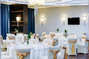 a set of tables and chairs in a room with a screen at Malak Regency Hotel in Sarajevo