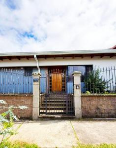 a house with a gate with a wooden door at Rohrmoser Eucalipto Luxe Residence in San José