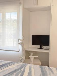 a bedroom with a desk with a television and a chair at Rohrmoser Eucalipto Luxe Residence in San José
