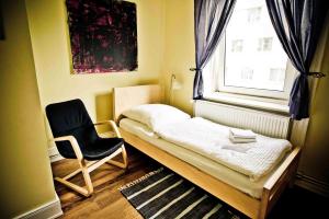 ein kleines Schlafzimmer mit einem Bett und einem Stuhl in der Unterkunft St. Pauli Lodge Townhouse in Hamburg