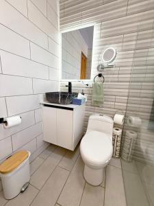 a white bathroom with a toilet and a sink at Rohrmoser Eucalipto Luxe Residence in San José +85 photos