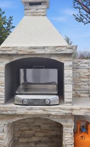 a barbecue grill in a stone oven in a backyard at Villa Kasandra - Ruhe & Eleganz in Buje, Istrien in Kaštel