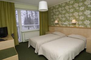 a hotel room with two beds and a window at Pühajärve Spa & Holiday Resort in Otepää +48 photos