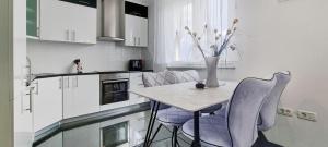 a kitchen with a table and chairs and a vase with flowers at Villa Kasandra - Ruhe & Eleganz in Buje, Istrien in Kaštel