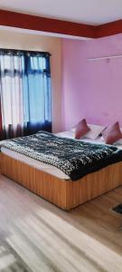 a large bed in a room with at Hotel Vamika in Manāli