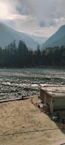 a river with a building on the side of it at Hotel Vamika in Manāli