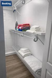 a walk in closet with shelves and towels at Modern Hard Rock Apartment in Miramar +14 photos