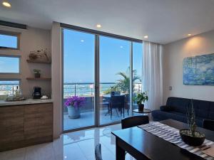 a living room with a couch and a table with a view at Hotel Perla Spondylus in Manta