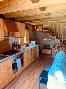 a kitchen with wooden cabinets and a couch in a room at Refúgio da Póvoa Dão in Silgueiros