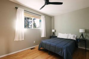 a bedroom with a bed with a ceiling fan and a window at Peaceful Mountain Sanctuary near Arrowhead Village in Lake Arrowhead