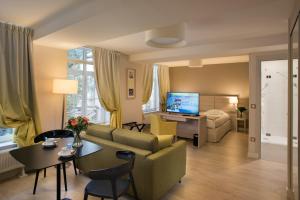 a living room with a couch and a table at Domitys - Le Carillon d'or in Maubeuge