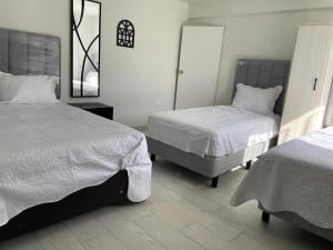 a bedroom with two beds and a mirror at Casa 3 super centrica ubicada al norte in Hermosillo