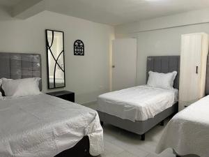 a bedroom with two beds and a mirror at Casa 3 super centrica ubicada al norte in Hermosillo