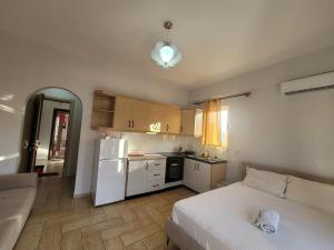 a small kitchen with a bed and a white refrigerator at Saranda Promenade Studio Apartment in Sarandë +5 photos