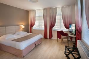 a bedroom with a bed and a desk and windows at Domitys - Le Carillon d'or in Maubeuge +34 photos