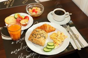 a table with two plates of breakfast food and a cup of coffee at Arena Hotel in Gelsenkirchen