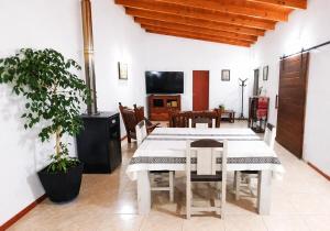 a dining room with a white table and a tv at Casa de campo in Puerto Madryn