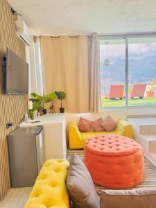 a living room with a couch and a large window at DUBAI by luxury Atitlan in San Pedro La Laguna