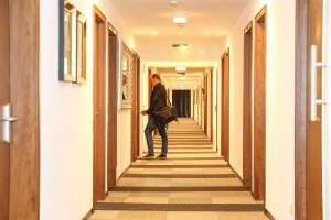 a woman walking down a hallway in a building at Arena Hotel in Gelsenkirchen